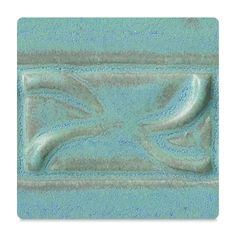 a blue ceramic tile with an ornate design on it's face and bottom corner