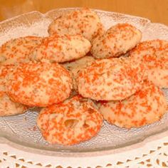 a plate full of cookies sitting on top of a table next to a glass bowl