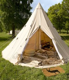 a teepee sitting on top of a lush green field