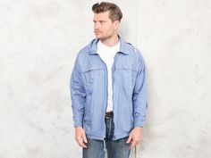 "Check out this vintage 90's men casual spring jacket in blue made of cotton. Classic look and fit for everyday wear. Vintage condition level 4 (very minor signs of wear) * MODEL is 6.0 ft (1.80 m) tall, size S / M - and he wears the size available. SIZE: Marked size: L. To be sure it would fit you, please check the measurements below. FLAT Measurements: Length: 29\" / 74 cm Armpit to armpit: 24 1/2\" / 62 cm SKU: M8060 (AMP) # As all our garments, this is previously washed, ironed and ready to Casual Cotton Windbreaker For Spring, Spring Cotton Windbreaker For Outdoor, 90s Style Track Jacket For Spring Outdoor, 90s Style Spring Outdoor Track Jacket, 90s Style Windbreaker With Pockets For Spring, Casual Cotton Track Jacket For Outdoor, 90s Cotton Windbreaker For Outdoor, Black Leather Jacket Men, Sport Jacket Men