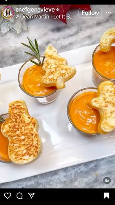 four small cups filled with food sitting on top of a white tray next to each other