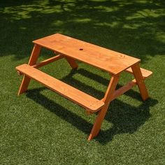 a wooden picnic table sitting in the grass