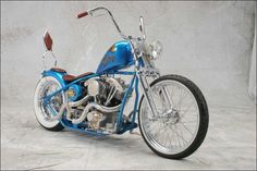 a blue motorcycle parked on top of a white floor