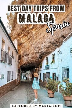 a woman in a blue dress and hat walking down an alley way with text overlay reading best day trips from malaga spain