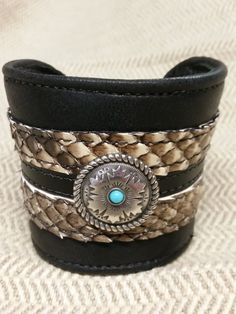 This is a 2 1/2 " wide cuff bracelet made with soft black cowhide with genuine python trim, and a beautiful concho accent. Buckle closure in back makes it adjustable.It is a very well made piece of wearable art for any occasion. Leather Cuff Bracelet With Concho, Leather Concho Cuff Bracelet, Bohemian Black Cuff Bracelet, Black Concho Jewelry For Rodeo, Western Leather Concho Cuff Bracelet, Unique Leather Cuff Bracelet With Concho, Handmade Western Cuff Bracelet, Western Black Leather Jewelry, Black Leather Western Jewelry