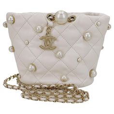 Store item: 67973 Chanel 21S White Cream About Pearls Bucket Bag Mini is a pillowy soft miniature bucket bag adorned with gold-pronged faux pearls and dangling CC charm hardware, with a woven crossbody strap. Perfect for evening or everyday, with easy access to essentials. In Cream lambskin leather and shiny gold hardware. This item is in excellent condition with very few signs of normal use. Corners are clean with no rubbing or scuffing. Hardware is clean and shiny. Interior is clean. Please view all 12 to 16 photos of the actual bag, for details, and ask any questions. Measures 6in. W (at widest point) x 4.5in. H x 4.2in. D, strap drop is 19.5 inches For 19 years, Boutique Patina has specialized in sourcing and curating the best condition vintage leather treasures by searching closets ar Chanel Pearl Bag, Chanel Bucket Bag, Navy Clutch, Navy Blue Purse, Vintage Chanel Bag, Mini Bucket Bag, Chanel Pearls, Chanel Mini, Pearl Bag