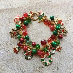 This Christmas charm bracelet is approx. 8 inches long and surrounded by green and red glass beads and holiday charms. #10 Handmade Green Beaded Bracelets For Holidays, Christmas Green Beaded Bracelets, Green Charm Bracelet With Lobster Clasp As Gift, Holiday Green Beaded Bracelets, Green Beaded Bracelets For Holiday, Green Beaded Bracelet For Holiday, Christmas Holiday Green Jewelry, Green Christmas Holiday Jewelry, Green Beaded Bracelets For Christmas