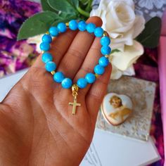 Super pretty blue beaded christian bracelet with a 18kt gold plated mini cross charm. This bracelet is made on super strong stretch cord and will fit most adults. It is really comfortable to wear and brightens up an outfit and can help you remember the LORD throughout the day with the reminder of the cross. Return to my shop : https://www.etsy.com/uk/shop/Sanctuswonders Thank you for visiting my shop! I hope you find what you are looking for! I specialise in and like to sell the following: Chris Gold Cross Beaded Bracelets For Gift, Gold Cross-shaped Beaded Bracelets For Gifts, Gold Beaded Rosary Bracelet With Cross Shape, Spiritual Cross Bracelet For First Communion, Gold Handmade Cross Rosary Bracelet, Elegant Cross Beaded Bracelets As Gift, Elegant Cross-shaped Beaded Bracelets For Gift, Blue Cross Bracelets As Gift, Blue Cross Bracelets For Gifts