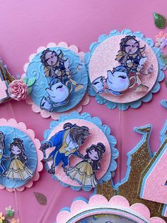 there are some pink and blue decorations on the wall with princesses in them,