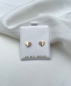 These adorable and dainty heart earrings are 14k gold made with high quality cubic zirconia. These stud earrings measure aprox 7.4mm and have a screw back closure. All photos are natural and have been taken to the best of our ability. ❤ We guarantee that the item is identical as the actual photo seen. ❤ We Guarantee 100% Pure 14K Gold ❤ Please feel free to message us with any questions you may have ❤ All our Items are Allergy free Thank You, ❤ Mushky S 14k Yellow Gold Heart Cut Earrings, Infant Gold Earrings, Dainty Tiny Yellow Gold Heart Earrings, Single Yellow Gold Heart-shaped Earring, Tiny Heart-shaped 14k Gold Earrings, Gold Bow Tie, Earrings Photo, Screw Back Earrings, Gold Studs