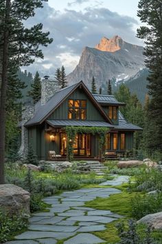 a house in the mountains with trees and grass on either side, surrounded by rocks