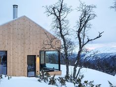 a wooden house on top of a snow covered hill