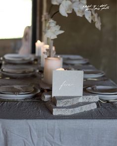 the table is set with plates, candles and napkins for an elegant dinner party