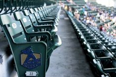 rows of green seats in an empty baseball stadium