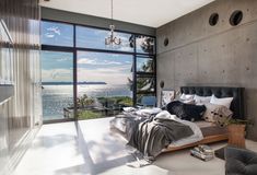 a bedroom with large windows overlooking the ocean