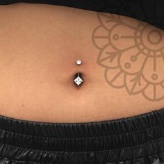 a woman's stomach with a small diamond on the middle part of her belly