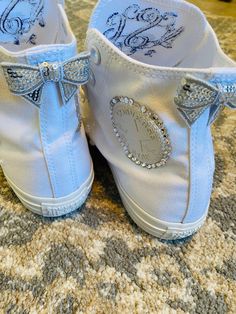 a pair of baby blue shoes with bows on the bottom and diamond embellishments