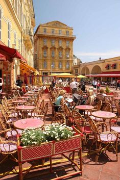 many tables and chairs are set up outside on the sidewalk in front of some buildings