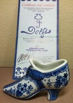 a blue and white shoe sitting on top of a wooden table next to a certificate