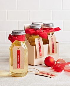 two jars filled with honey sitting on top of a table next to ribbons and decorations