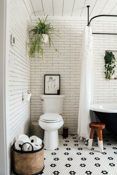 a white toilet sitting next to a black bath tub