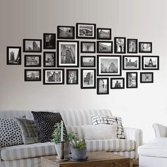 a living room filled with furniture and framed pictures on the wall above it's coffee table