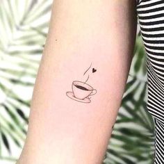 a cup of coffee with a heart on the side of her arm is shown in black ink