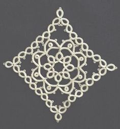 a white brooch with an intricate design on it