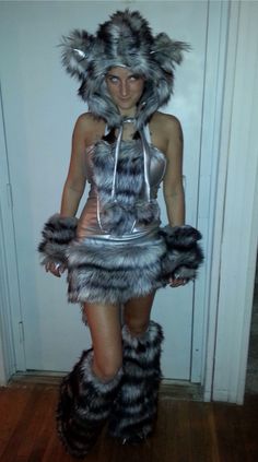 a woman wearing a costume made out of furry animal furs and silver metal chains