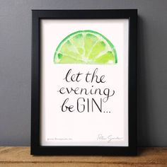 a framed print with the words let the evening be gin on it and a slice of lemon