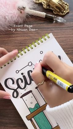 a person is writing on a notebook with a pen and some other items around them