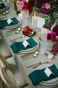 the table is set with place settings and flowers