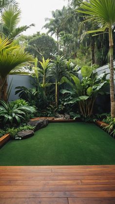 an outdoor area with wooden decking and tropical plants