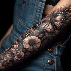 a woman's arm with flowers and butterflies on it, in black and white