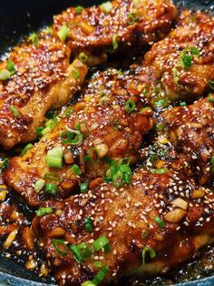 chicken with sesame seeds and green onions in a skillet, ready to be eaten