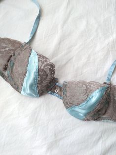 Beautiful vintage balconette bra in a light blue color by designer, Christian Dior. Features floral lace and satin cups, hook and eye closure with three hook options, underwire, and a dainty floral bead in the center. Era: Circa 1970s Condition: Excellent Size: 34C Color: Light blue, gray Brand: Christian Dior Measurements: 13in band width at the last hook Fabric Content: 60% polyester, 40% nylon (lace); 100% imported polyester (panel); 79% nylon, 21% spandex (elastic) MORE INFO: *Please, note that all items are vintage. Therefore, it is expected to find some wear. Ariessence by Ariel is an admirer of fashion history and hopes you can appreciate this garment and its character. The condition and any damages will be indicated to the best of my ability. Vintage sizes may also vary compared to Elegant Light Blue Bra, Elegant Light Blue Bra With Padded Cups, Elegant Light Blue Padded Bra, Fitted Lace Bra In Light Blue, Blue Lace Bra With Removable Pads, Fitted Blue Bra With Lace Closure, Light Blue Underwire Bra With Padded Cups, Dior Floral, Pearl Applique