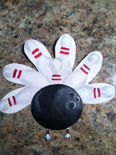 a bowling ball with pins sticking out of it sitting on top of a marble floor