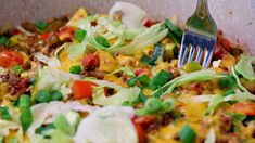 a salad with lettuce, tomatoes, and other toppings in a bowl