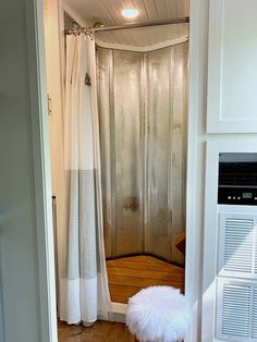 a bathroom with a shower and a white rug on the floor in front of it