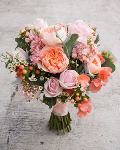 a bouquet of pink flowers is sitting on the ground