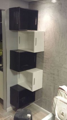 a room with black and white boxes on the wall next to a toilet in it