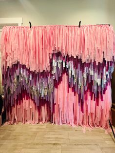 there is a pink and purple curtain hanging on the wall