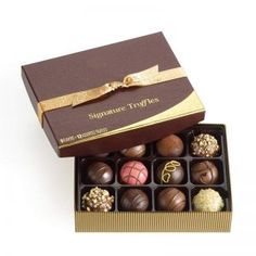 an assortment of chocolates in a box with a bow on the front and side