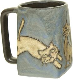 a ceramic mug with two cats on it