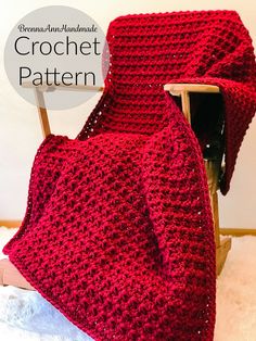 a red crochet blanket sitting on top of a wooden chair