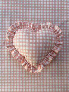 a heart shaped pillow sitting on top of a checkered table cloth