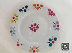 a white plate with colorful flowers painted on it