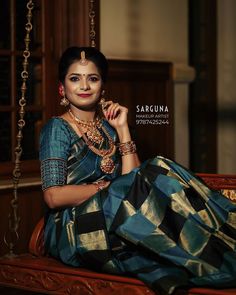 a woman sitting on top of a swing in a blue and gold sari dress