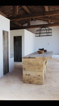 an empty room with a wooden table in the center and two doors on each side