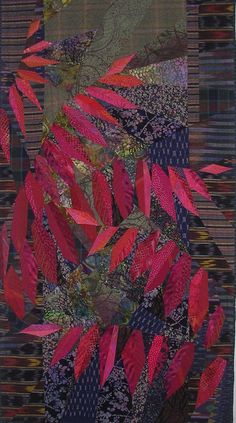 a quilted wall hanging with red leaves on it